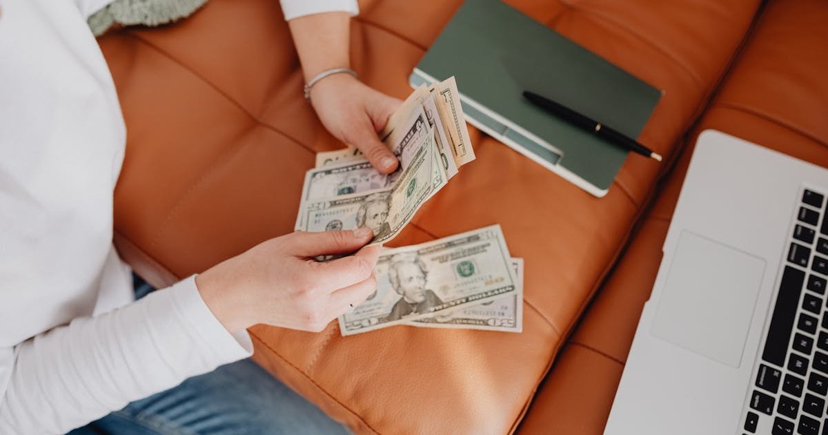 Freelancer reviewing budgeting app dashboard on laptop with income charts